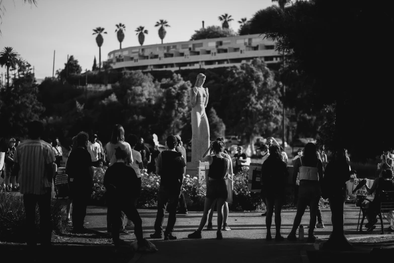 a black and white po of people standing outside near palm trees