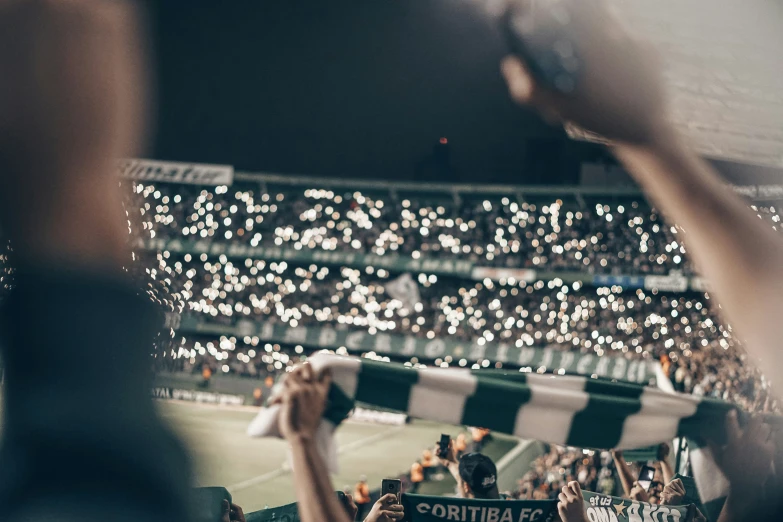 fans hold up their flags as they watch a game