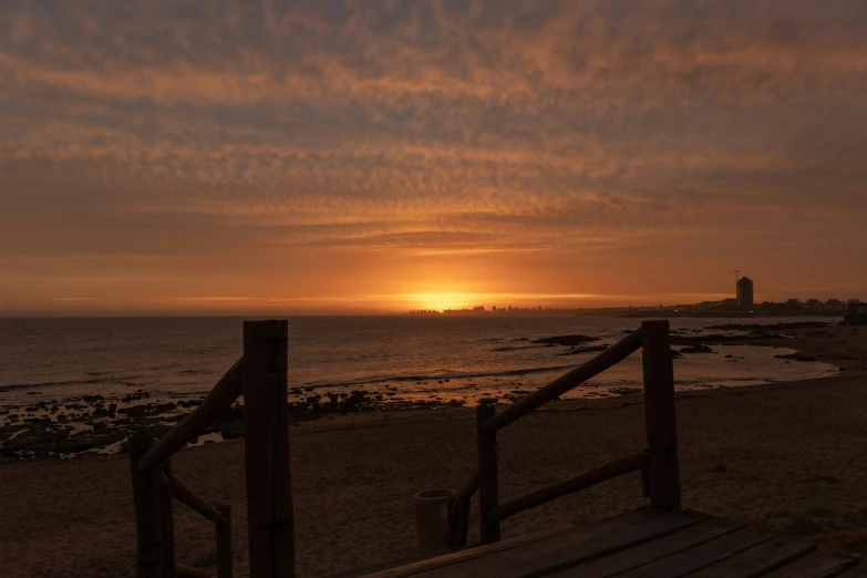 the sun setting behind the horizon on the beach