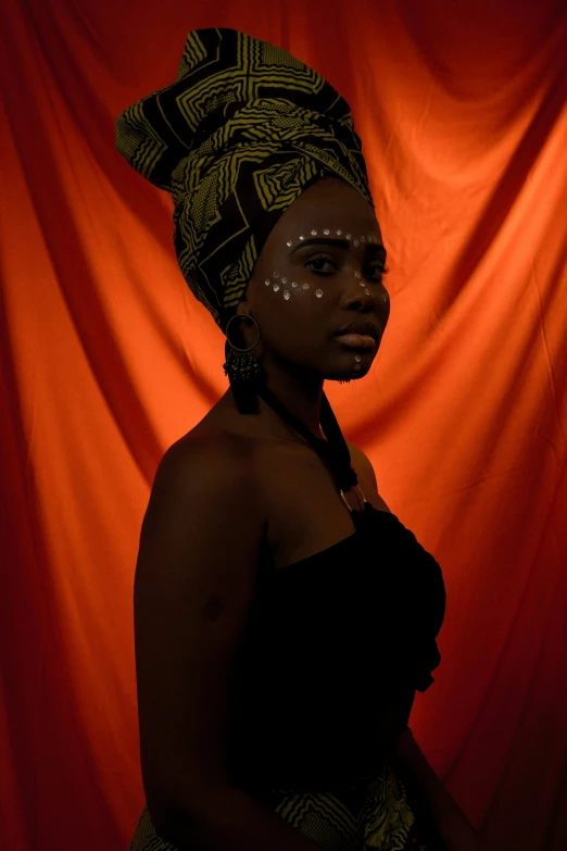 a woman wearing a turban in front of red background