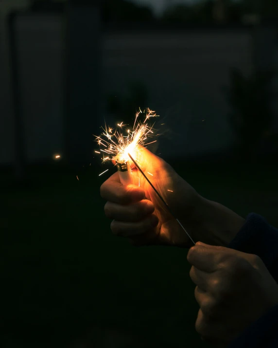 someone holding a sparkler in their hand and lighting it