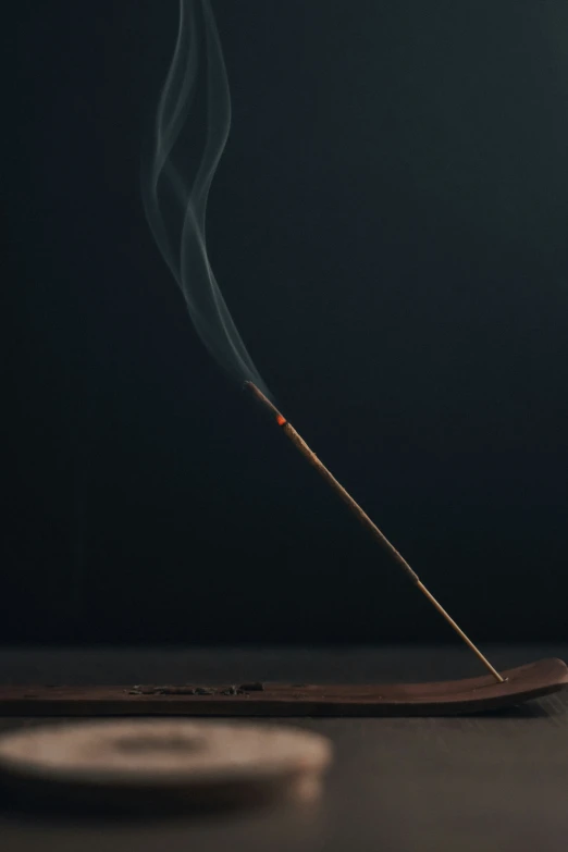 a single stick of matches sits on the counter in front of a black background