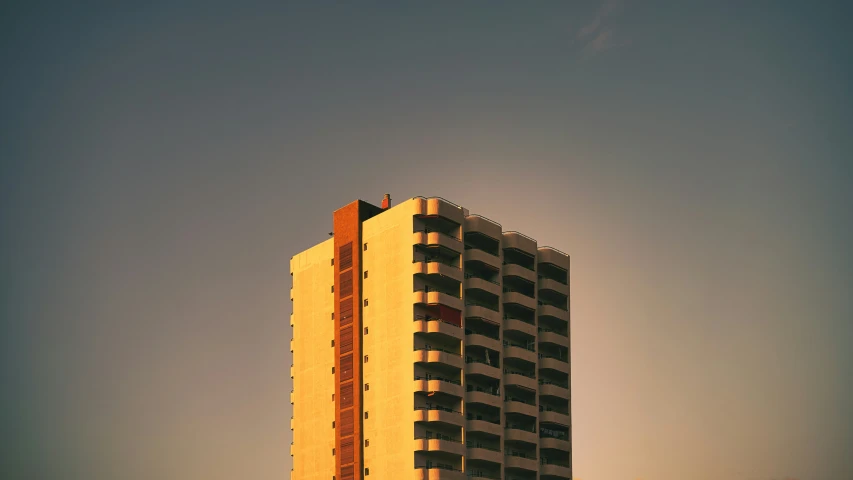 a tall building is silhouetted against the sky