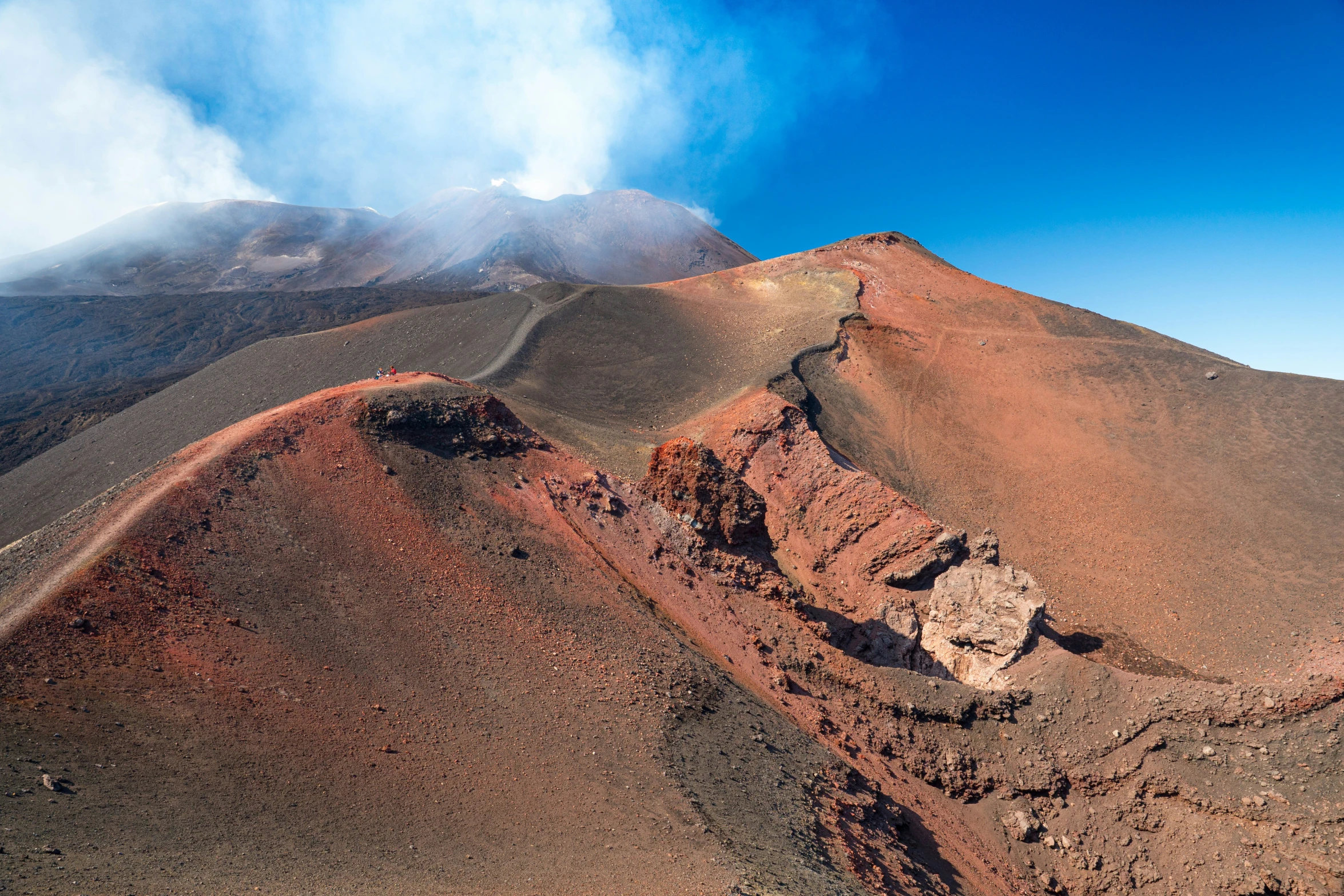 aerial pograph of the top of a steep mountain with a blue sky