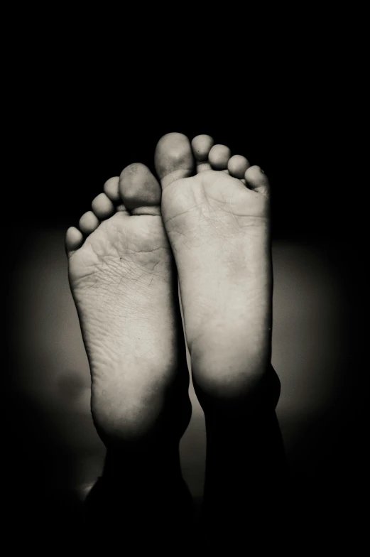 a close up view of someones bare foot with stones on them