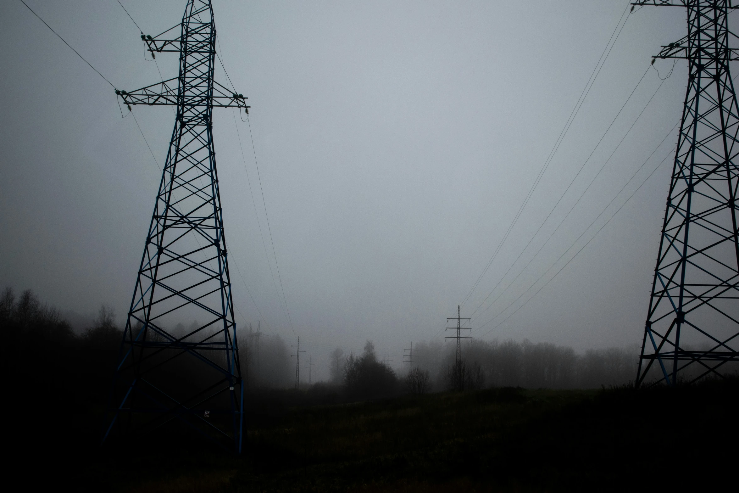 two power towers stand on the edge of a hill