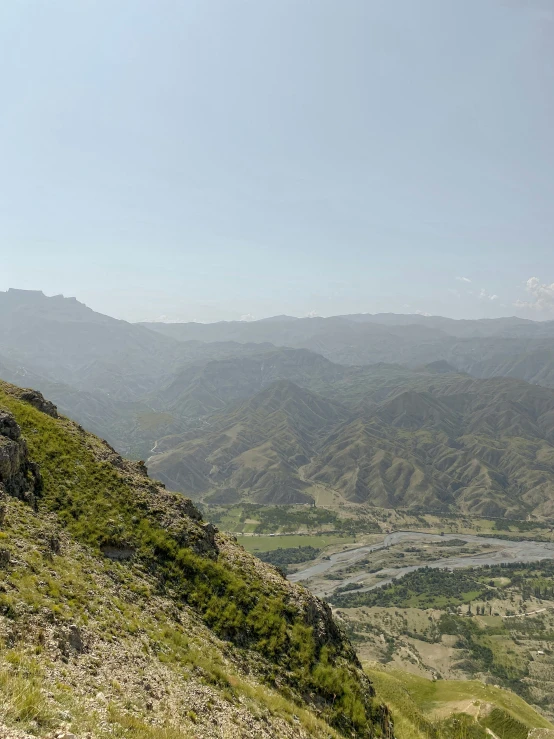 a man sitting on a hill top with his dog