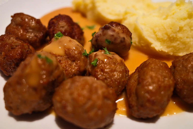 an asian style meal that includes meatballs, mashed potatoes, and green onion