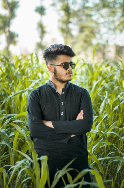 a man standing in a field wearing sunglasses