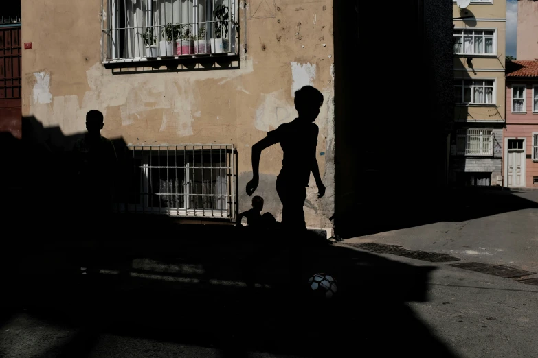 a silhouette of two people standing in front of a building