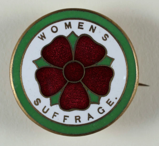 a badge showing women's suffrage underneath it