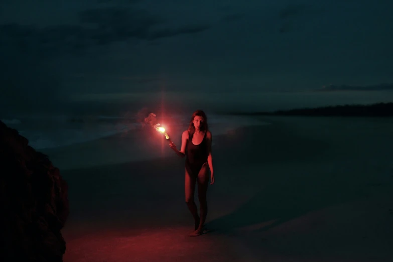 a girl in a swimsuit holding up red lights