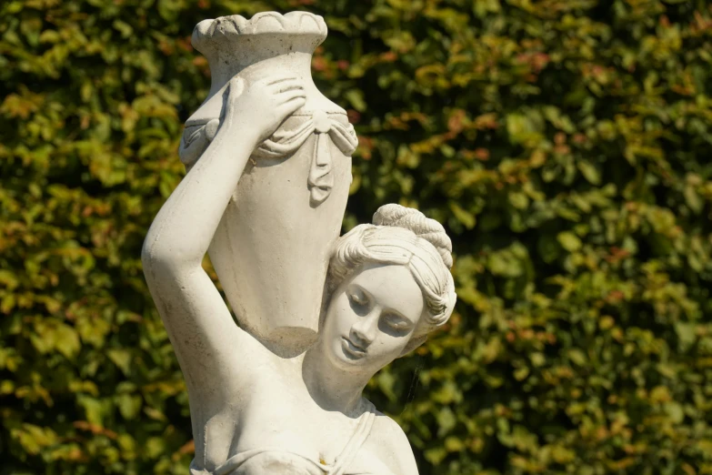 a stone statue of a woman holding a vase