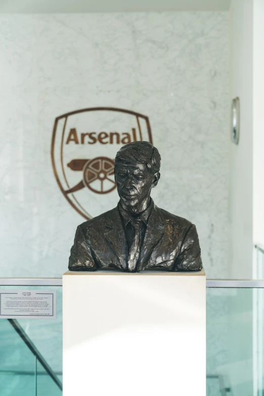 a statue sitting on top of a base in front of an arena logo