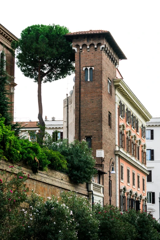 a tall brick building sitting next to a tree