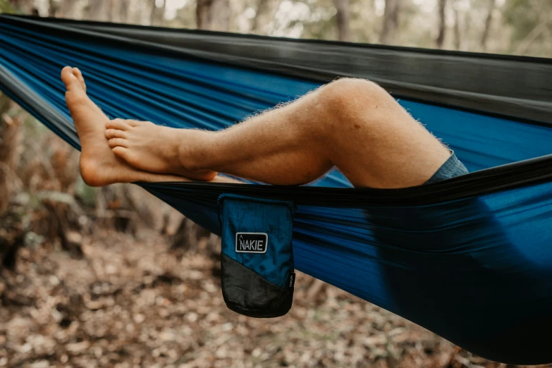 a man sleeping in a hammock on top of a tree