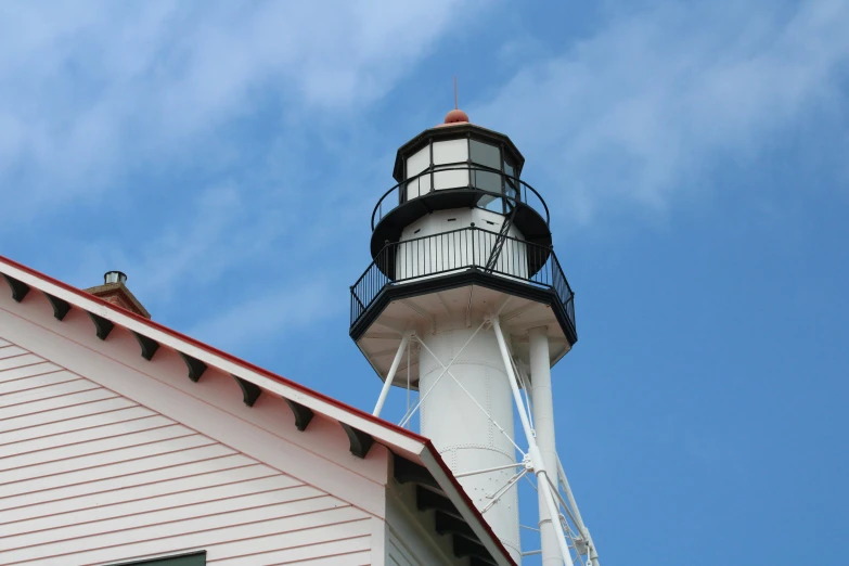 a large white lighthouse with a black top on a building