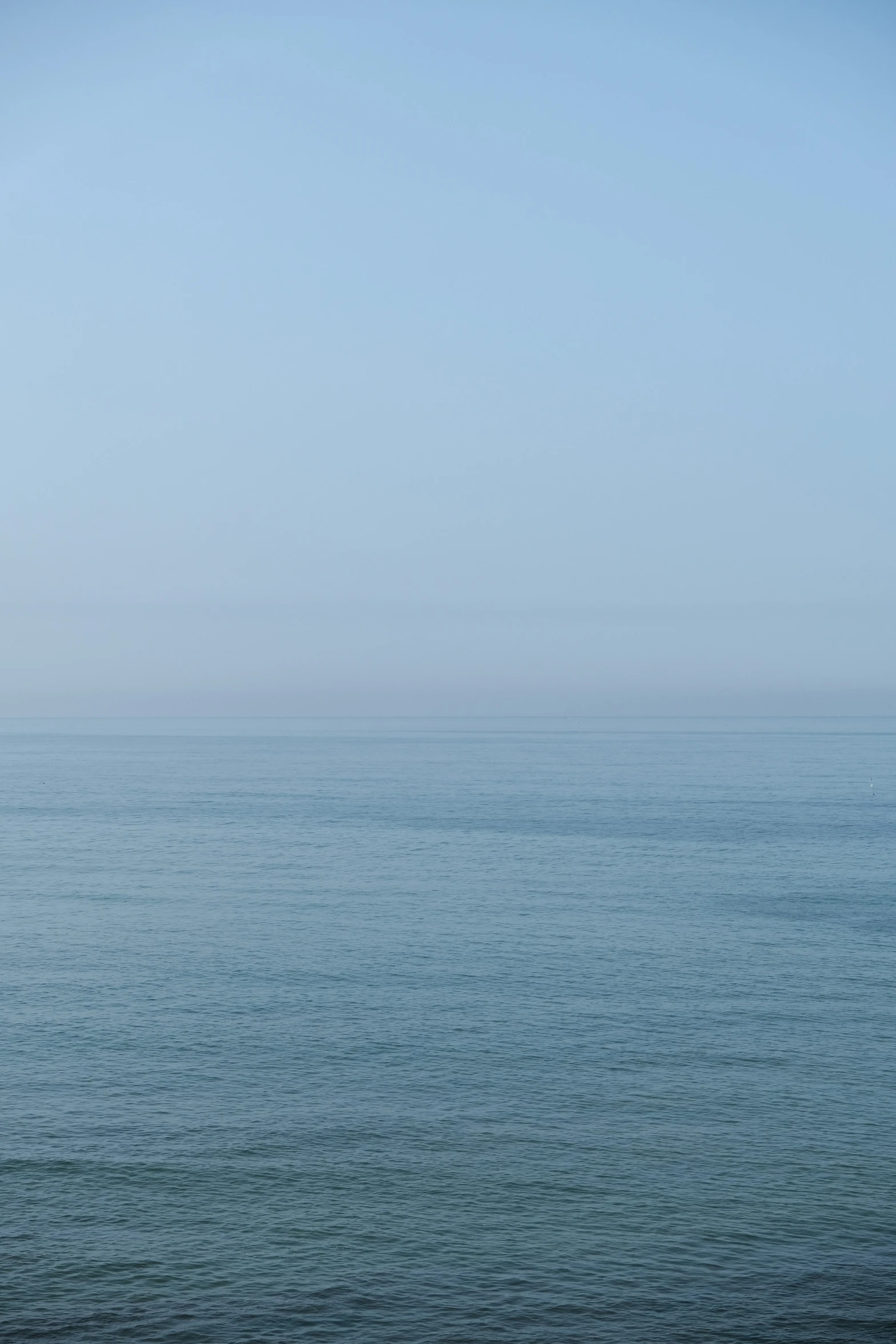 a sailboat sailing across the ocean on a sunny day