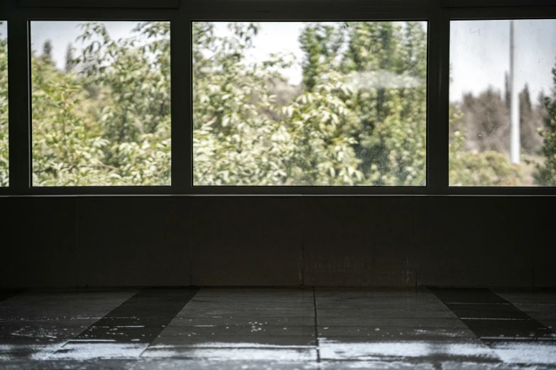 an open window in a house with trees behind it