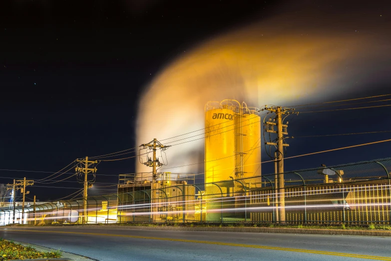 a factory with yellow smoke coming from it