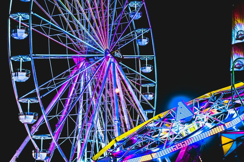 a ferris wheel in color lit at night