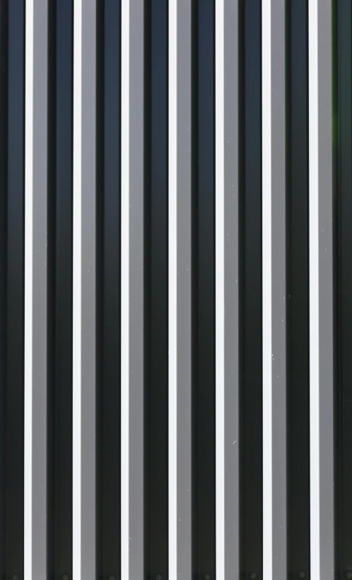 a gray and white striped wall near street signs