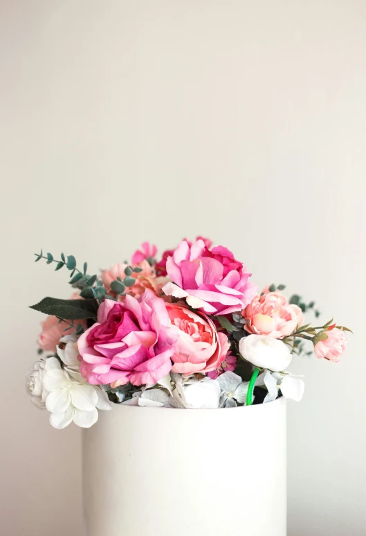 a close up of a bunch of flowers in a white vase