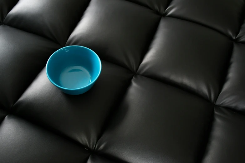 a blue bowl on a black quilt