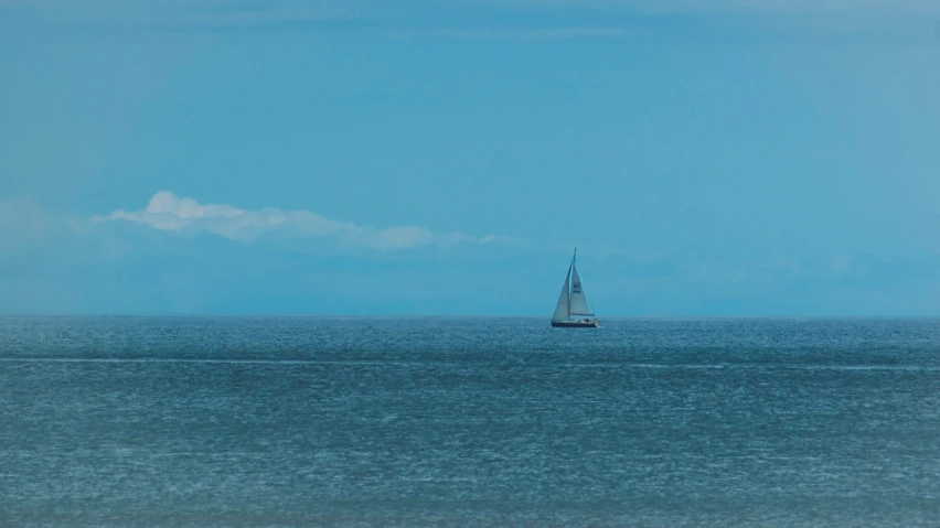 a boat sails in the blue ocean on a sunny day