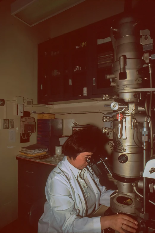 woman standing in front of an experiment device looking into it