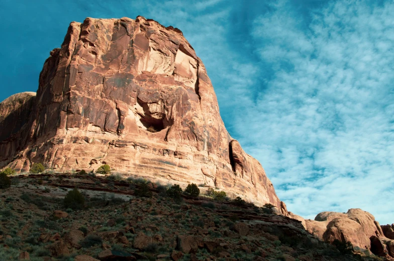 a large rocky hill with a face carved on the side