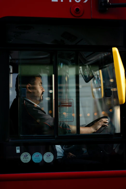 a man driving a bus in front of a stop sign