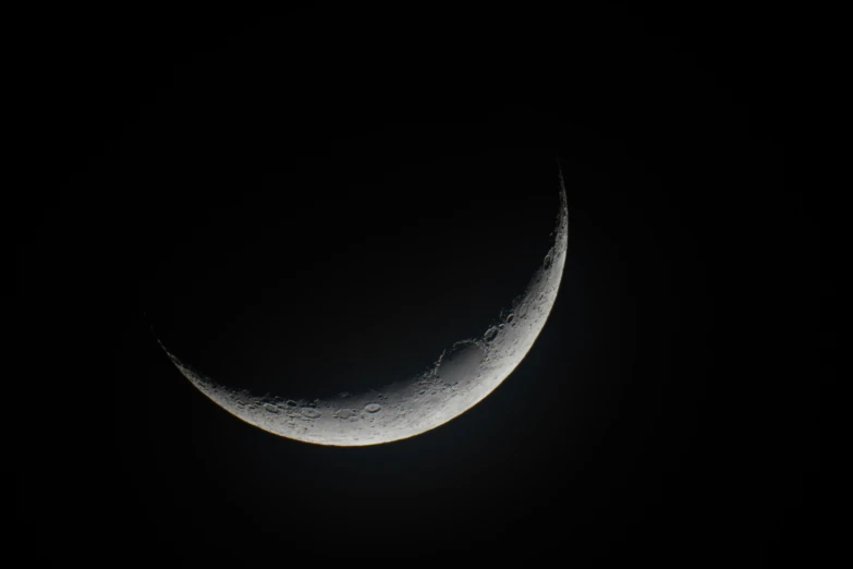 an half moon that is sitting in the dark sky