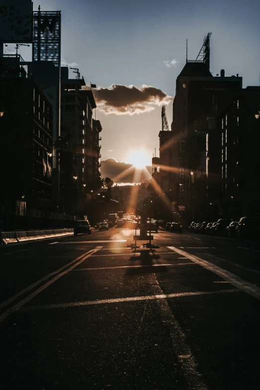 the sun is setting over a city street