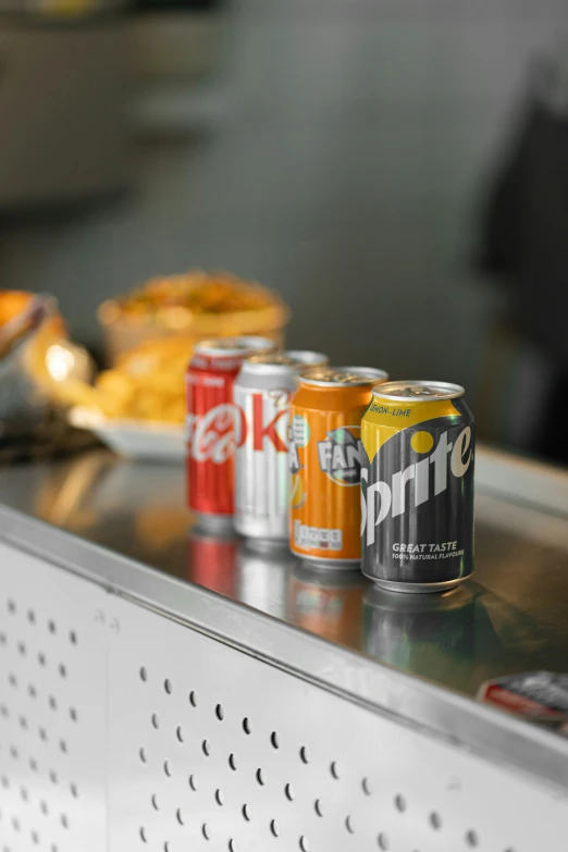 an assortment of soft drink cans on top of the cooler