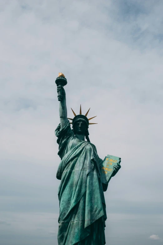 the statue of liberty stands on the top of a hill