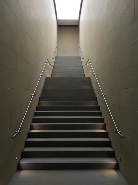 a staircase going up into a hallway with light coming in