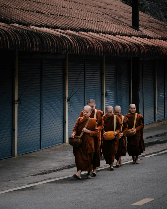 a group of monks are walking down the street