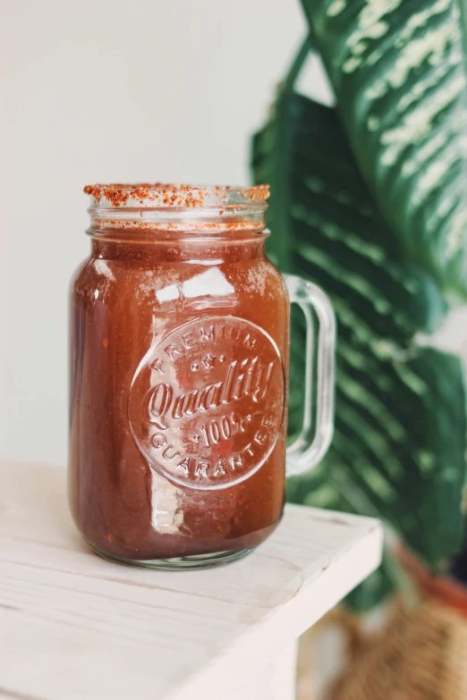 a mason jar with cinnamon paste sitting on top of a wooden table