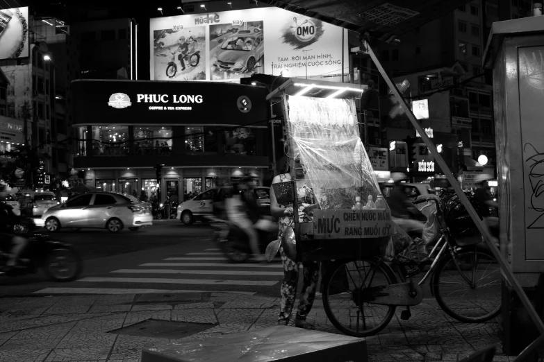 a black and white po shows traffic in front of a public service booth