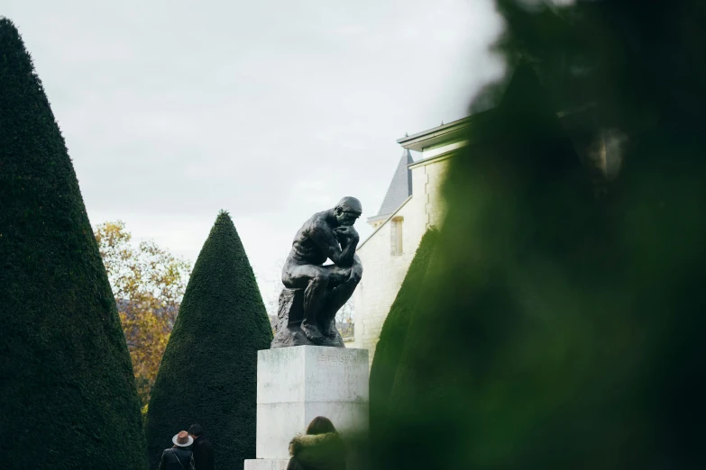 a man standing next to a tall sculpture