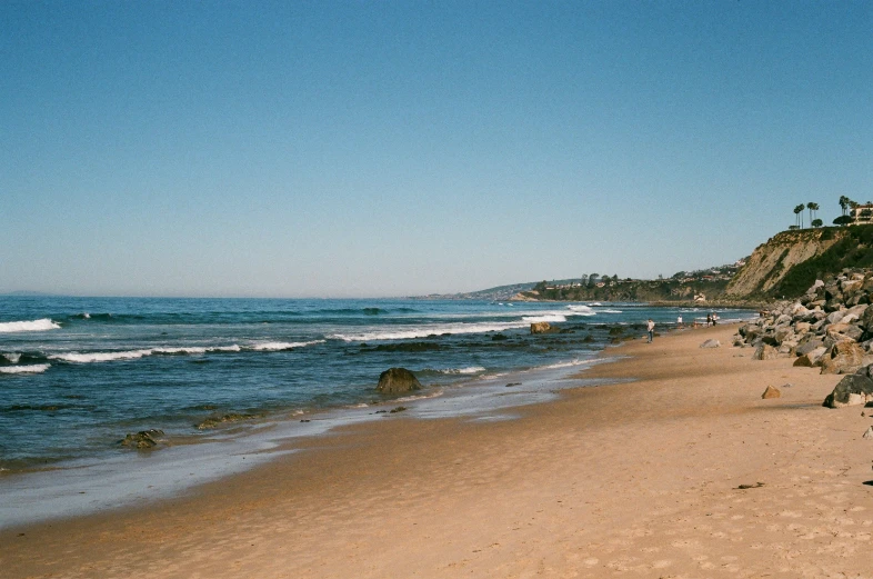 people on the beach walking to and from the water