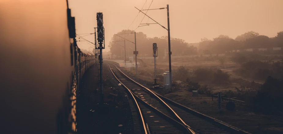 the sun is shining brightly above a long train