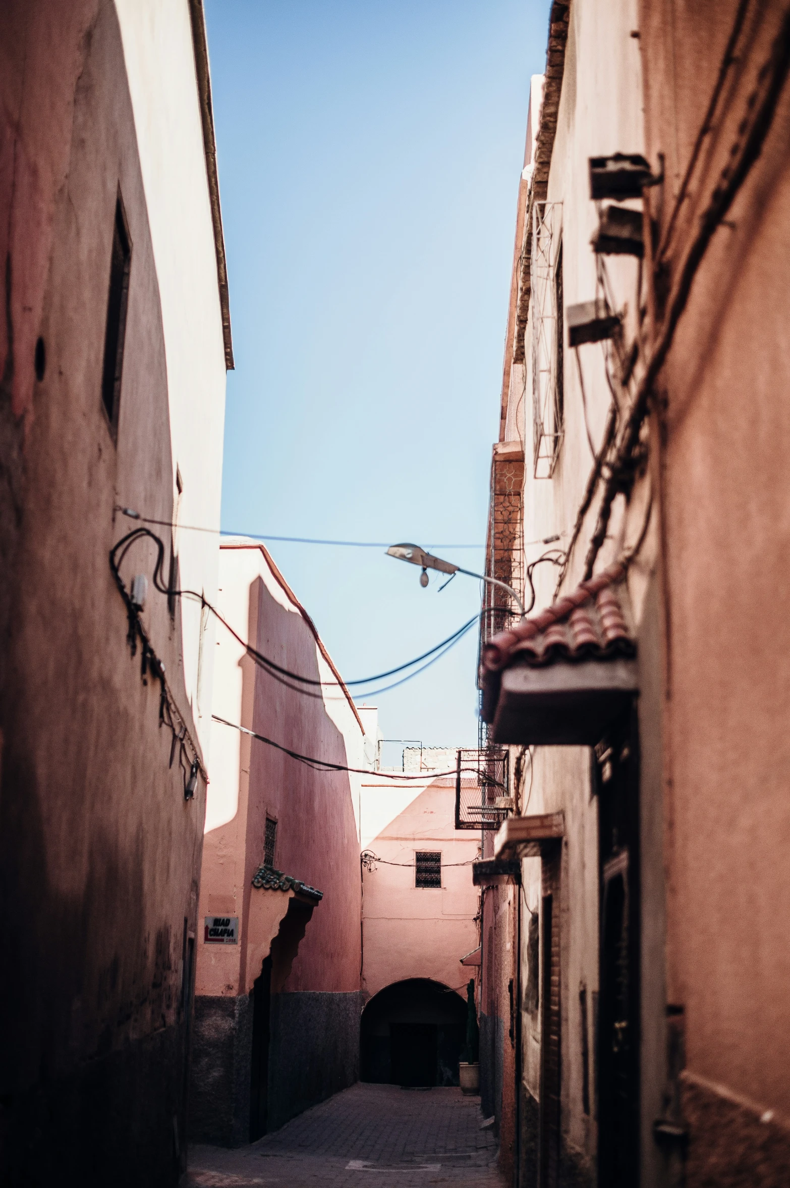 a narrow alley with one lone street light in between