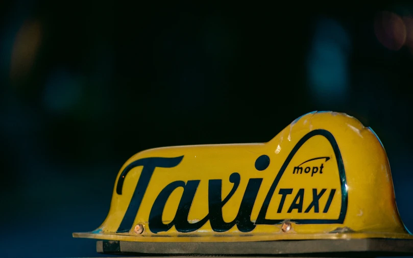 a taxi sign with the word taxi printed on it