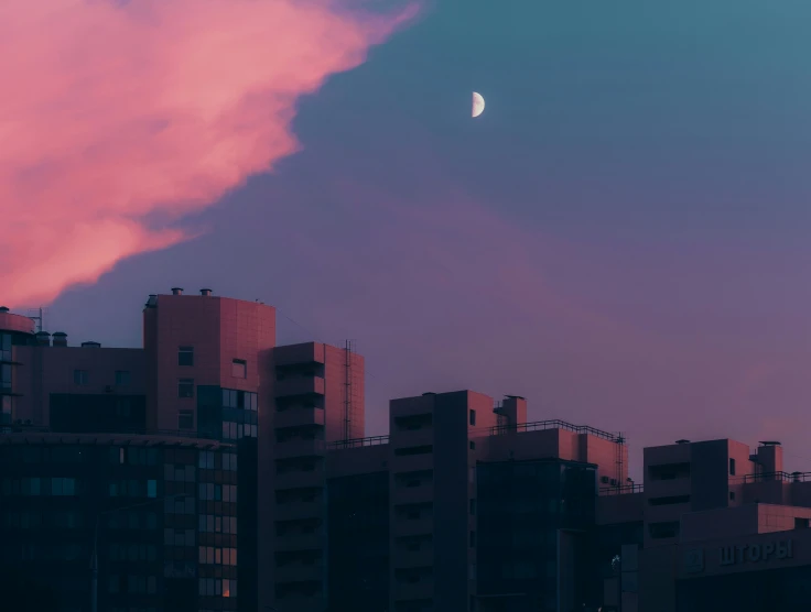 a cloud over buildings and a moon