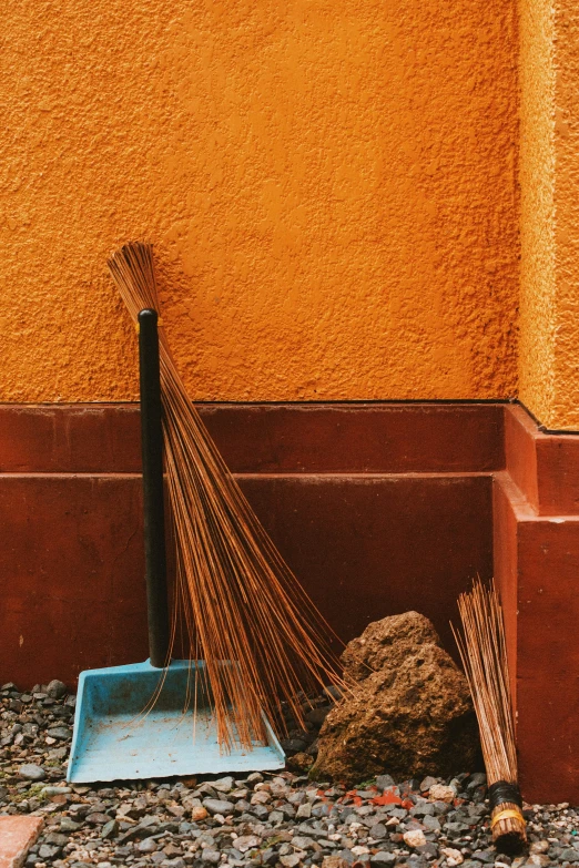 the broom is on the ground next to a pile of rocks