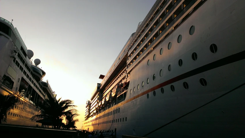 people are walking down a street beside a large ship