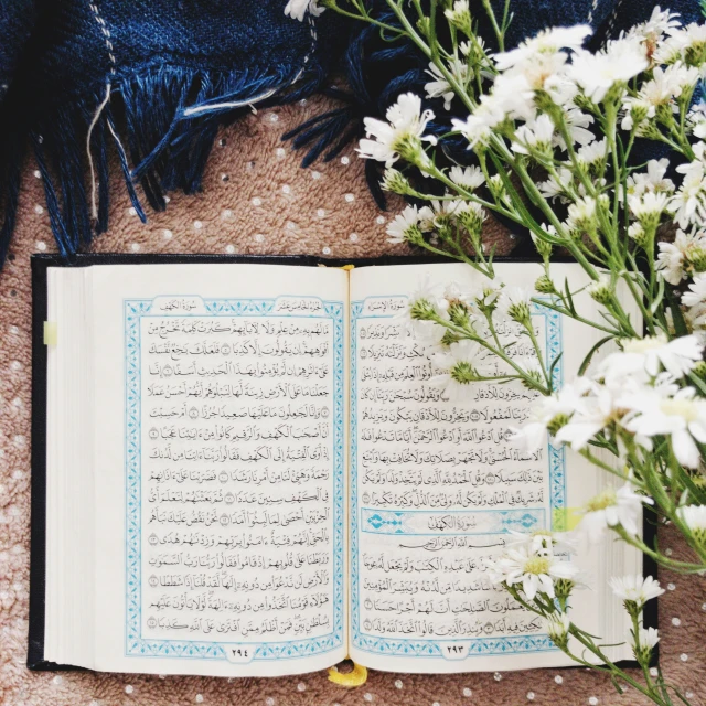 an open book laying on a carpet with flowers