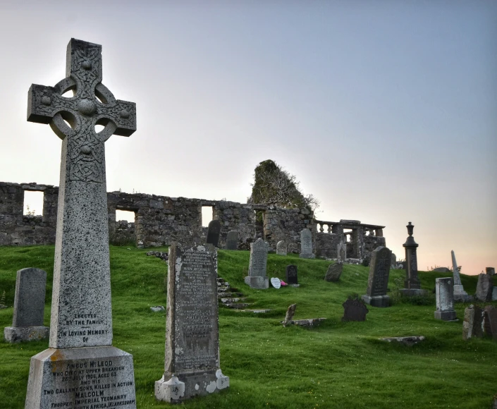 an old cemetery with tombstones, crosses and a plaque